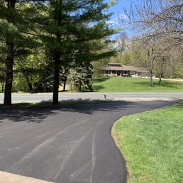 a paved driveway with trees in the background