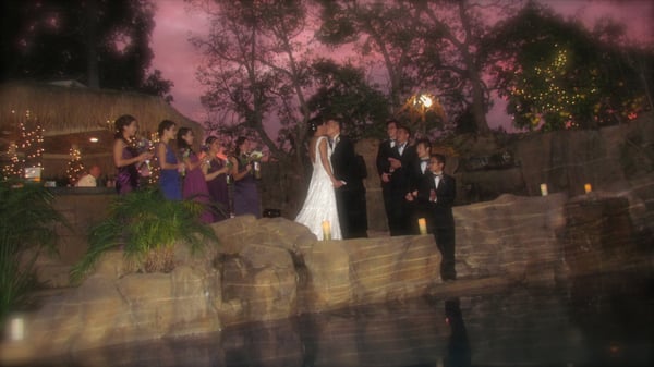 Weddings and Private Events - The Enchanted Manor offers you a one-of-a-kind, romantic and unforgettable wedding experience. Our facility allows your wedding dreams to come true and your planning stress to disappear. The casual yet elegant atmosphere lends itself for guest to immediately feel comfortable to mingle with guest. People are in awe of its magical vibe The Enchanted Manor emanates. They come as strangers and leave as friends.

Your wedding plans will experience no limits with The Enchanted Manor’s outdoor surroundings, spacious professionally landscaped property, convenient location and experienced event hosting. Along with providing a peaceful and elegant setting for your wedding, The Enchanted Manor can assist in the planning of your special day.

The outdoor area includes a custom designed sculpted pool area featuring with three waterfalls with 9 different colors of lights to choose from. A stone patio, a thatch covered Gazebo Bar equipped with refrigerator, sink and barbecue. An outside fireplace with a comfortable seating area, fire-pit with seating for six, a multi-level wood deck and custom specialty lighting that has the effect of walking in dappled moonlight.

There’s room for seating for up to 110 people for dinning. There are many different areas that can serve as the central point for the bride and groom for the ceremony. Most choose the ledge that juts out over the pool with the waterfall cascading beside them. The front area of the grounds at The Enchanted Manor offer a classic old country-style backdrop for the wedding ceremony. Guests can be seated on either side of a brick walkway which leads up to a stone archway with beautiful large arched wooden doors.

Since same-sex marriage has become legal in California, The Enchanted Manor has become a popular location for Gay and Lesbian weddings and ceremonies. The intimate setting is a perfect choice for your special day.