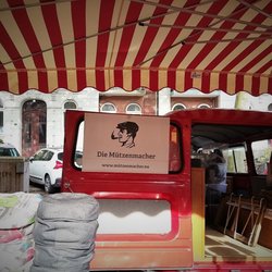 Die Mützenmacher - Ausschnitt des Marktstandes