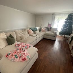 Our freshly cleaned living room with the cutest touch, our Christmas blanket shaped into a bow!