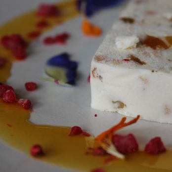 Rigo - White Chocolate Cassata is italian ice cream cake with walnuts, macadamia nuts, dried fruits, lilikoi sauce, and pink pepper. - Spanish Near Me - Honolulu, Hawaii