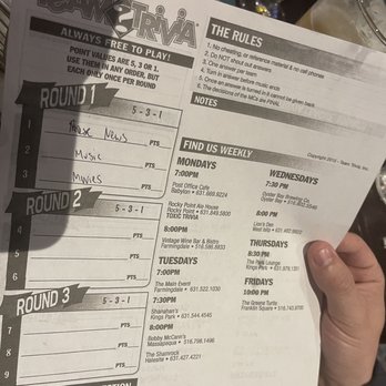 Lion's Den - a person holding a menu - Bars Near Me - West Islip, New York
