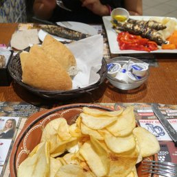 Home cut chips on steak in the foreground. Sardines in the background.