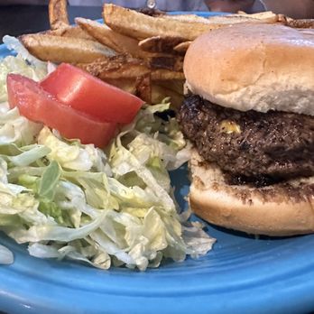 Lindy's Diner - a hamburger and french fries - A cheeseburger with a beef patty, bun, and melted cheese, served with French fries and a side salad with tomato slices on a blue plate. - Diners Near Me - Albuquerque, New Mexico
