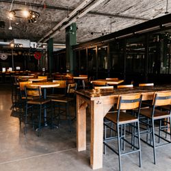 Brühaven Craft Company - Bar area high tops next to axe throwing cages