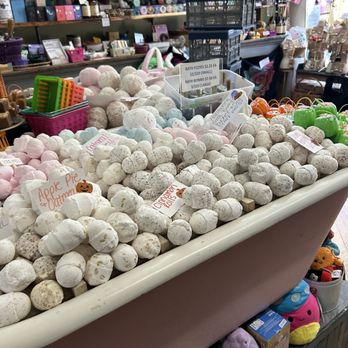 Sunrise Soap - A store display features bath fizzies and bath bombs in different colors and sizes, with signs indicating prices. Shelves with various personal care and gift items are visible behind the display. - Cosmetics & Beauty Supply Near Me - Gettysburg, Pennsylvania