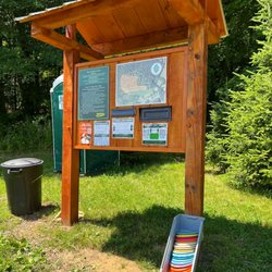 Oakholm Disc Golf - Trail head sign, payment information, loaner discs, garbage and portable potty located at course entrance.
