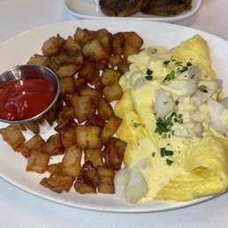 OMELETTE OSCAR: three-egg omelet, fines herbes, asparagus, crabmeat, hollandaise; served with Brabant potatoes