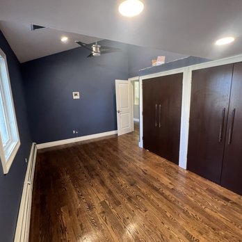 Excellence Home Improvements - an empty room with wood floors - General Contractors Near Me - Merrick , New York