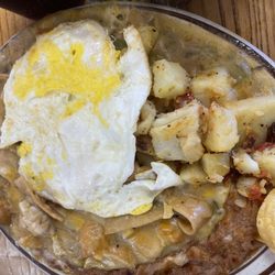 La Escondida Cafe - Breakfast chilaquiles with chicken and an over hard egg. Side of refried beans and country potatoes