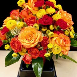 The Nature Shoppe - Orange, yellow, and red roses and carnations liven up the room!