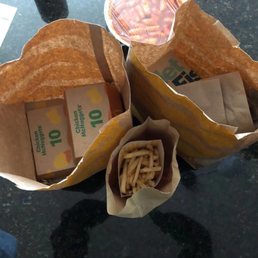 two paper bags of food on a table two paper bags of food on a table