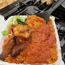 Jollof rice, chicken, plantains, and salad