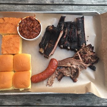 Fette Sau - Clockwise from top left: cornbread, burnt ends baked beans, pork ribs, brisket, spicy pork sausage, and buns. - Barbeque Near Me - Brooklyn, New York
