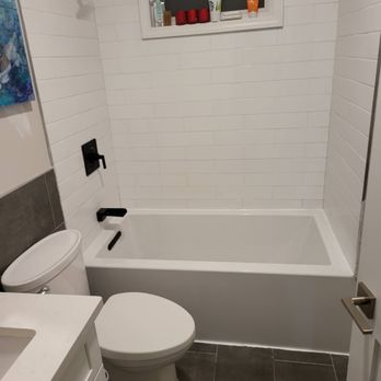 Jm Handyman - a bathroom with a toilet and tub - Painters Near Me