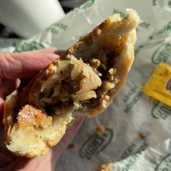 Runza - a hand holding a half eaten sandwich - Burgers Near Me - Loveland, Colorado