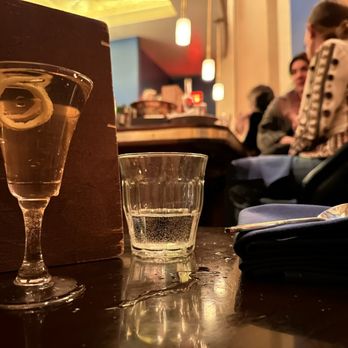 Tonic - a glass of water and a lemon slice on a table - Cocktail Bars Near Me - Santa Fe, New Mexico