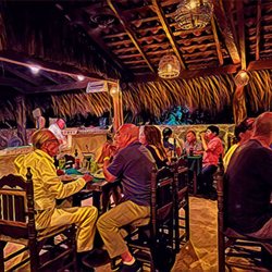 Jungle Pizza - People enjoying their friends company and the pizza with the oven in the background.