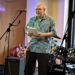 Mark. On stage, reciting his poem.