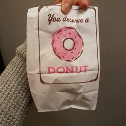 a person holding a bag of donuts a person holding a bag of donuts