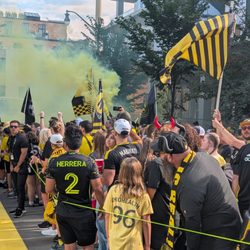 Supporters march to the yellow carpet to welcome the team to the staduyn