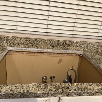 Counter Elegance - Our cutout after. - Granite kitchen countertop with a rectangular cutout for a sink, and visible plumbing inside the cabinet. - Countertop Installation Near Me - Phoenix, Arizona