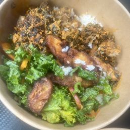 Coconut rice, chicken, kale salad, and spinach with egusi stew