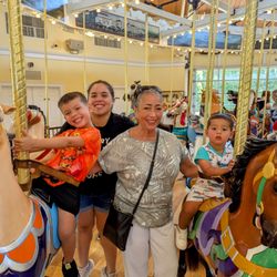 Nunley's Carousel - Family of four smiles for photo.