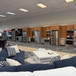 Queen City Homestore - Display wall of appliance packages including refrigerator, dishwasher, range and microwave