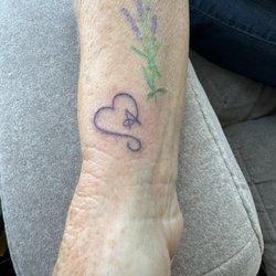 Living Arts Tattoo - Her new tatoo below a previously obtained tatoo.