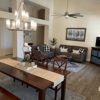 FloorEver Interiors - Beautiful new floors in our living/dining room. - Living room featuring two gray sofas with plaid pillows, a wooden coffee table, a ceiling fan, and wall art, with a dining table and chandelier nearby. - Flooring Near Me - Chandler, Arizona