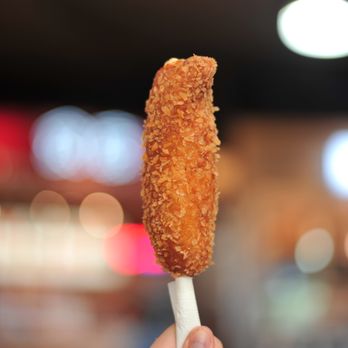 Tokki - a person holding a fried food item - Korean Near Me - Coquitlam, British Columbia