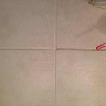 The Grout Specialist Co - Applying bone-colored grout stain.  (dirty old grout on right, newly applied still-wet stain on left) - Grout Services Near Me