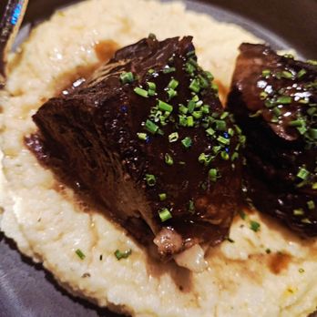 Immigrant Food Ballston - SLOW BRAISED SHORT RIB Creamy polenta, pomegranate molasses, spicy chermoula - New American Near Me - Arlington, Virginia Immigrant Food Ballston - SLOW BRAISED SHORT RIB Creamy polenta, pomegranate molasses, spicy chermoula - New American Near Me - Arlington, Virginia