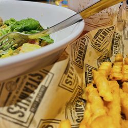 Steamies Burger Bar - Caesar salad, basket of fries and a fountain drink