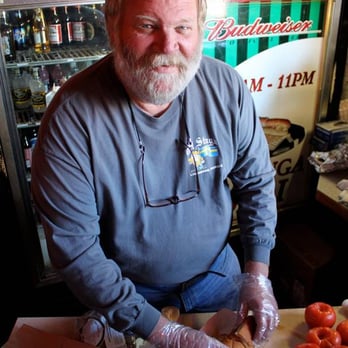 Ol Stuga - a man cutting tomatoes on a cutting board - Bars Near Me - Lindsborg, Kansas
