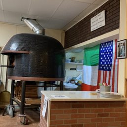 Pizza oven & kitchen behind the flags