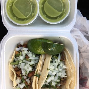 Los Compayes - Al pastor (left) and carne asada (right) tacos with 2 limes and 2 to-go containers of salsa verde ($4.06) - Mexican Near Me - Omaha, Nebraska