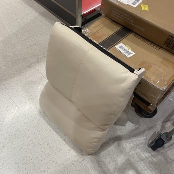 Target - A beige upholstered chair is positioned against a shopping cart filled with cardboard boxes in a retail store aisle. - Department Stores Near Me - Cupertino, California