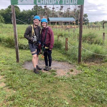 Us in our gear after the final zip back to the ground with the ropes course behind us.