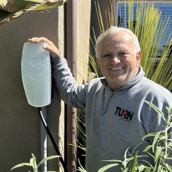 Turn Electric - Steve next to the Tesla universal charger he installed at our home. - Electricians Near Me - Los Angeles, California Turn Electric - Steve next to the Tesla universal charger he installed at our home. - Electricians Near Me - Los Angeles, California