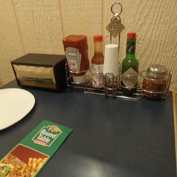 Round Table Pizza - A good number of condiments are provided (our pepper and Parmesan cheese shakers were next to me when I took the pic). - Pizza Near Me - San Lorenzo, California