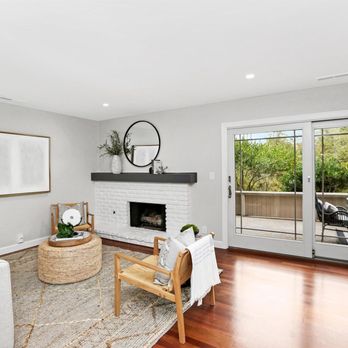 Imagine Construction - a living room with hardwood floors and a fireplace - General Contractors Near Me