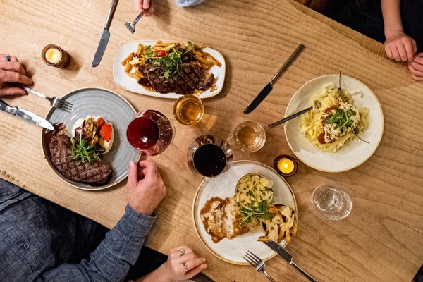 Photo of Barnwood - Niagara Falls, ON, CA. a group of people sitting at a table with plates of food