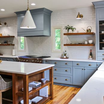 Nine Mile Cabinetry - Blue lower cabinets with crisp white quartz and natural wood floating shelves for a bright, airy feel. - Cabinetry Near Me Nine Mile Cabinetry - Blue lower cabinets with crisp white quartz and natural wood floating shelves for a bright, airy feel. - Cabinetry Near Me