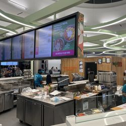 Tropical Smoothie Cafe - Fairly large setup at an airport with large open kitchen area and bar stools around it with power outlets.