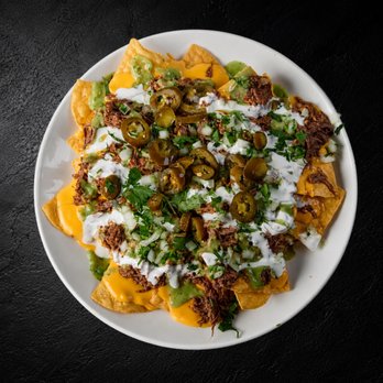 Fuego Cravings - Crispy tortilla chips loaded with rich nacho cheese, tender birria, creamy sour cream, fresh guacamole, diced onion, cilantro, and jalapeños - Mexican Near Me - Beaumont, California Fuego Cravings - Crispy tortilla chips loaded with rich nacho cheese, tender birria, creamy sour cream, fresh guacamole, diced onion, cilantro, and jalapeños - Mexican Near Me - Beaumont, California