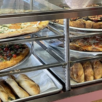 J & V Pizzeria - Their ready-to-go counter of pizzas and sandwiches that just need a mild reheating. - Pizza Near Me - Brooklyn, New York J & V Pizzeria - Their ready-to-go counter of pizzas and sandwiches that just need a mild reheating. - Pizza Near Me - Brooklyn, New York