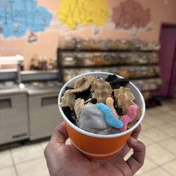 Tops Yogurt - Milk chocolate yogurt with cookies and cream, waffle crumbs, and gummy worms.