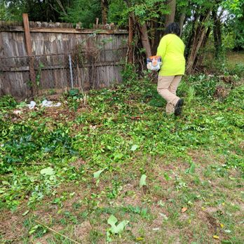 Lawns $50 - a man in a yellow jacket picking up weeds - Lawn Services Near Me Lawns $50 - a man in a yellow jacket picking up weeds - Lawn Services Near Me